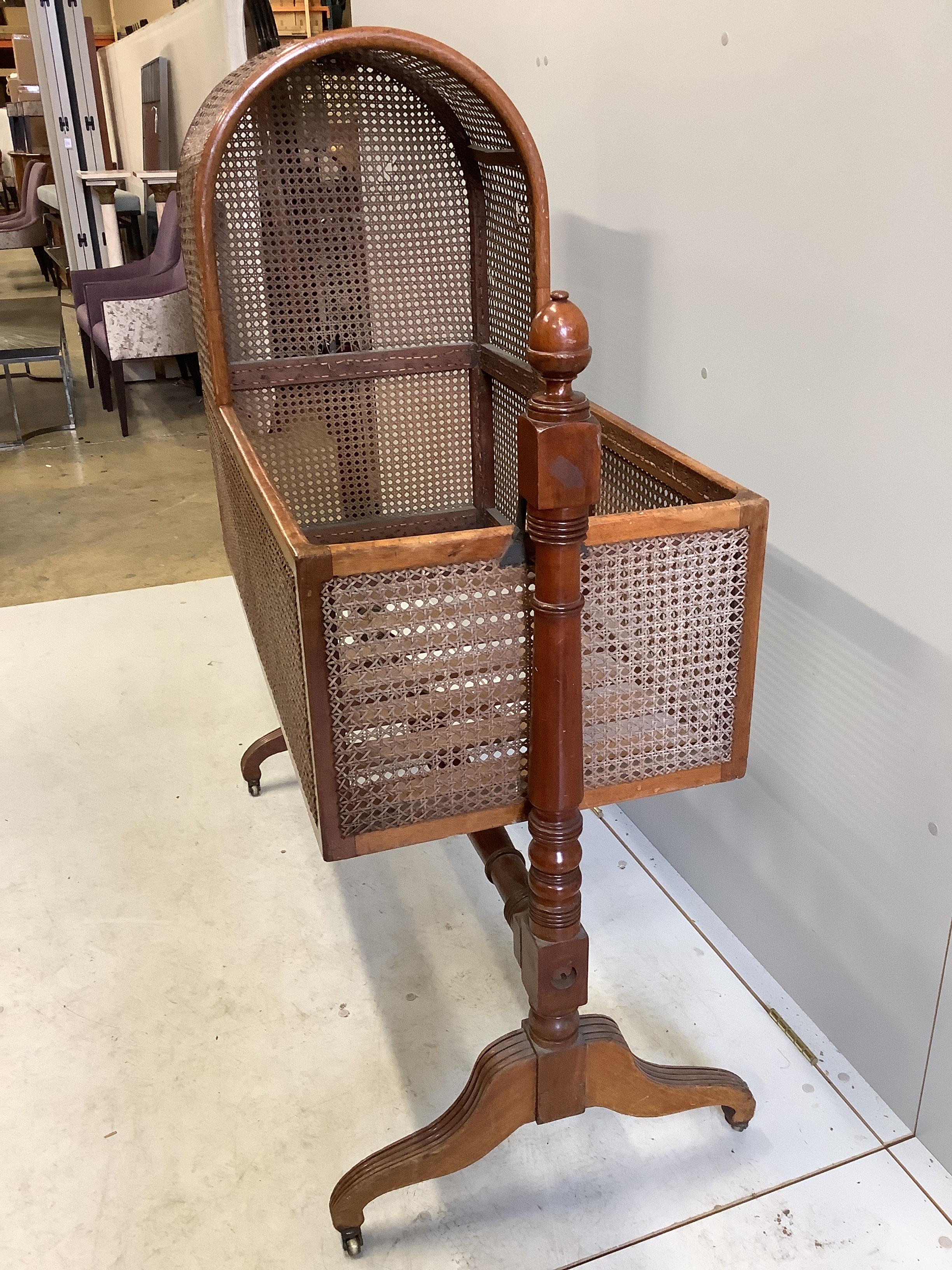 A George IV caned mahogany rocking crib, width 112cm, depth 51cm, height 135cm